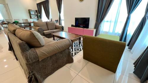 a living room with two couches and a tv at Camelia Homestay in Melaka
