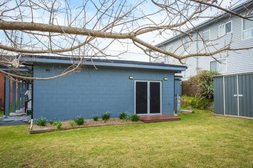a blue house with a yard at Sun Kissed on Dulling in Dalmeny