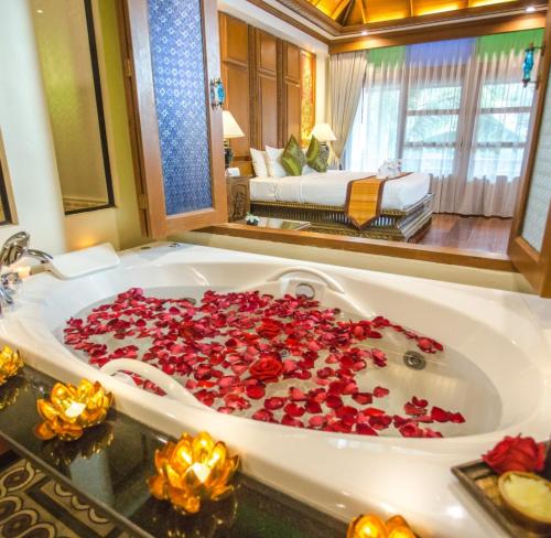 una vasca da bagno piena di rose rosse in una stanza di Pingviman Hotel a Chiang Mai