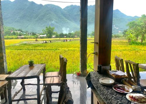 a table and chairs with a view of a field at Mai Chau Countryside Homestay in Mai Chau