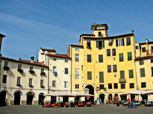 a large yellow building with tables in front of it at Apartment in Lucca near Piazza Napoleone in Lucca