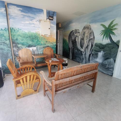 a living room with a bench and chairs and a mural at Haadrin village Fullmoon in Haad Rin