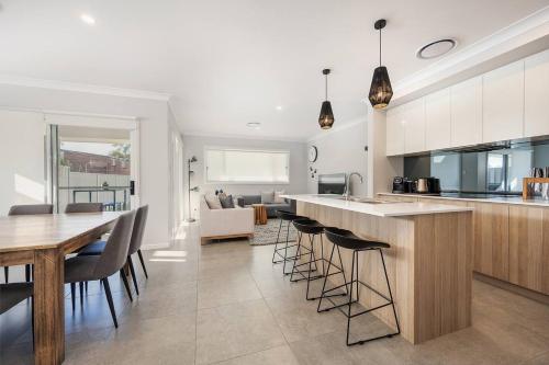a kitchen and dining room with a table and chairs at 'Huxley House' An Elegant Mudgee Retreat with Backyard in Mudgee