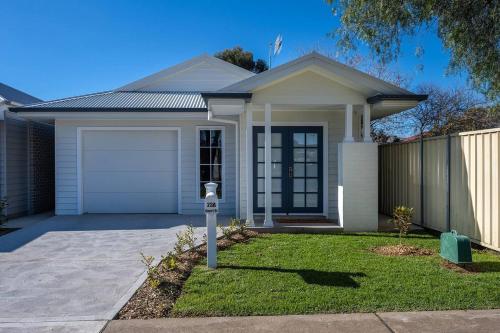 a white house with a parking meter in front of it at 'Huxley House' An Elegant Mudgee Retreat with Backyard in Mudgee