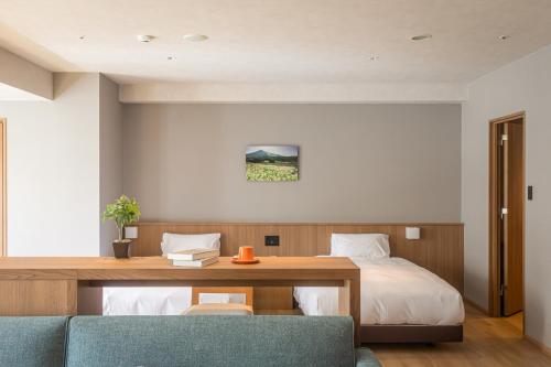 a hotel room with a bed and a desk and a bed sidx sidx sidx sidx at Higashikawa Asahidake Onsen Hotel Bear Monte in Higashikawa