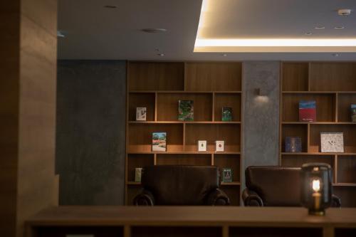 a waiting room with two chairs and a book shelf at Higashikawa Asahidake Onsen Hotel Bear Monte in Higashikawa