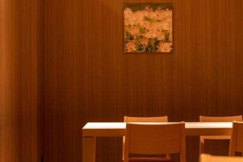 a room with tables and chairs and a painting on the wall at Higashikawa Asahidake Onsen Hotel Bear Monte in Higashikawa
