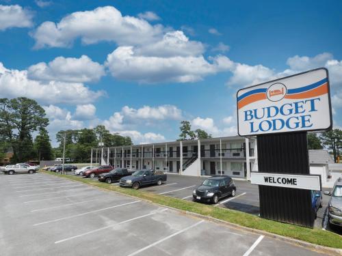 a hotel with a sign in front of a parking lot at Budget Lodge Churchland in Chesapeake
