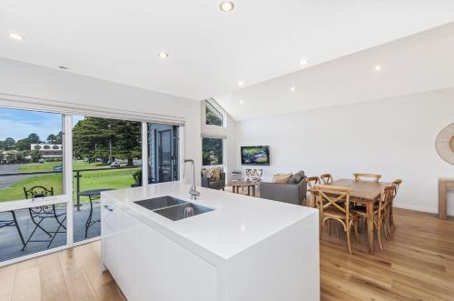 a kitchen and living room with a table and chairs at Absolute in Port Fairy