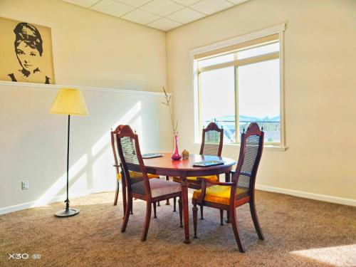 een eetkamer met een tafel en stoelen en een raam bij 1 bedroom lake Mountain view in West Kelowna