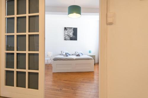 Una puerta que conduce a un dormitorio con cama en KASA ZAMBEZE - Spacieux - WIFI en Saint-Étienne