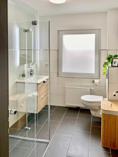 a bathroom with a glass shower and a toilet at Dock 6 - Cuxhaven in Cuxhaven