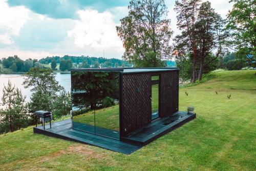 a tiny house on a hill next to a body of water at ÖÖD Hötels Rõuge in Rouge