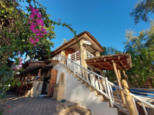 a house with a staircase leading up to a building with flowers at La Bella Donna in Ifaty