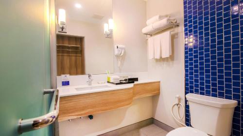 a bathroom with a sink and a toilet and a mirror at Holiday Style Ao Nang Beach Resort, Krabi in Ao Nang Beach