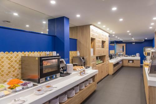a kitchen with blue walls and a counter with food at Holiday Style Ao Nang Beach Resort, Krabi in Ao Nang Beach