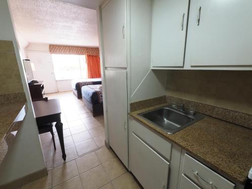 a kitchen with a sink and a room with a couch at White Marlin Inn - Virginia Beach in Virginia Beach