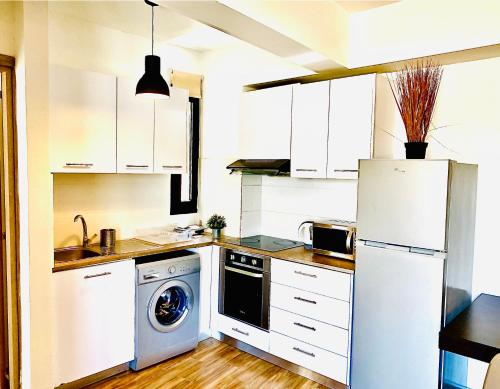 a kitchen with a white refrigerator and a dishwasher at BALI SUITES 101 in Larnaka