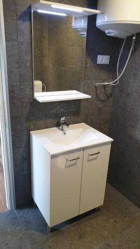 bagno con lavandino bianco e specchio di Apartman River 2 a Foča