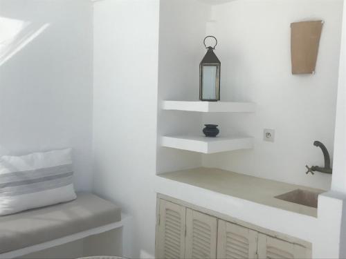 eine Küche mit weißen Wänden, einem Waschbecken und Regalen in der Unterkunft Dar 23 in Tangier