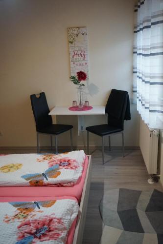 a room with two beds and a table and chairs at Gegg`s Fe-Wo oder Doppelzimmer in Dollnstein