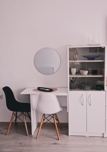 a white kitchen with a table and two chairs at Central Park Studio in Onești