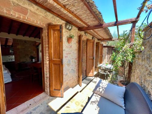 a patio of a house with a couch and an open door at Monteriggioni Castello in Monteriggioni