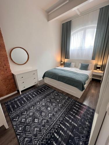 Schlafzimmer mit einem Bett, einem Spiegel und einem Teppich in der Unterkunft Luxus Citywohnung in Hannover in Hannover