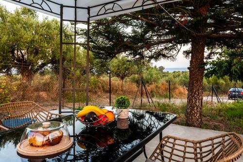 a table with a bowl of food on top at Makarounis Athanasios Traditional Apartments(Ξενώνας) in Petalidhion