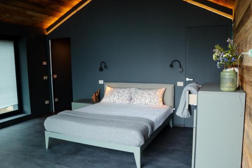 a bedroom with a bed and a blue wall at Le Volpi Luxury Apartments in Gressan