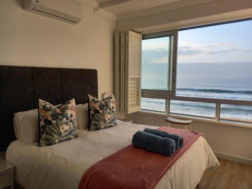 a bedroom with a bed with a view of the ocean at Modern & Luxurious Beachfront Villa in Ballito