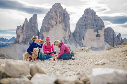 a group of three girls and a dog on a mountain at Ariane's Guesthouse in Sesto