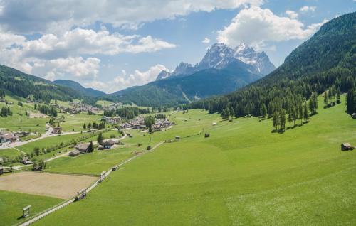 a green field with a village and mountains in the background at Ariane's Guesthouse in Sesto