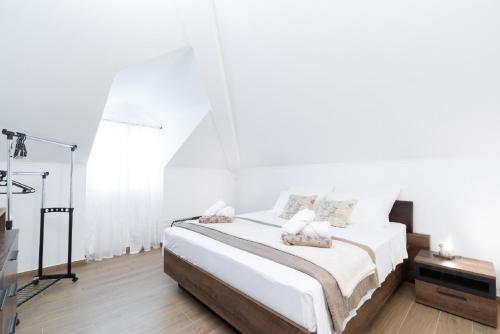 a white bedroom with a bed with white sheets at Apartment Dragojevic in Vela Luka