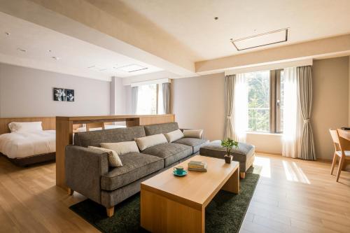 a living room with a couch and a table at Higashikawa Asahidake Onsen Hotel Bear Monte in Higashikawa