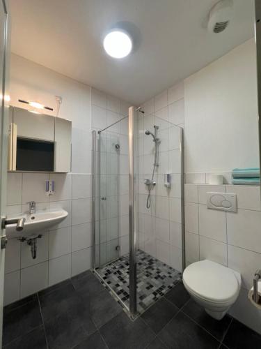 een badkamer met een douche, een toilet en een wastafel bij Motel am Outletcenter in Neumünster