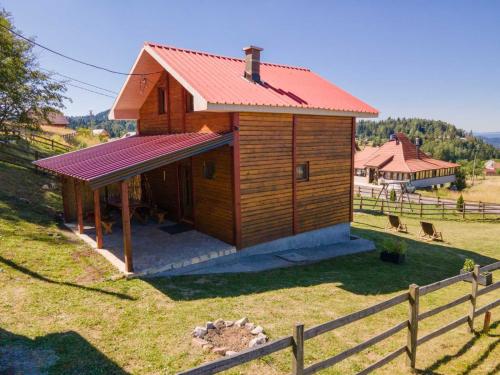 a small wooden building with a red roof at Planinska kuća Petrović in Zaovine