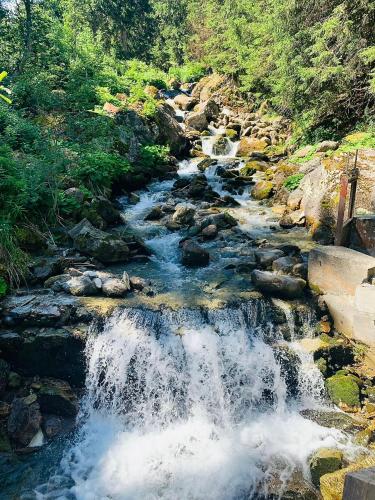 a stream of water rushing down a rocky river at Chalet la Tulipe, mountain view, Terrace, BBQ in Nendaz