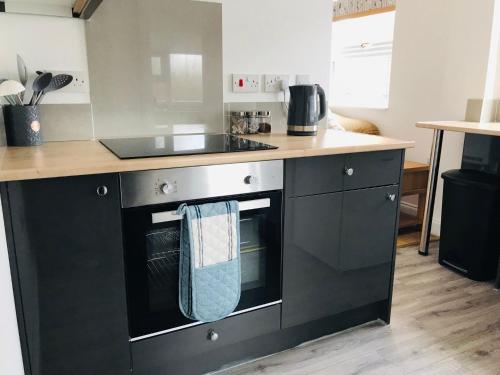 a kitchen with a stove top oven with a blue towel at Character Town Centre 1 Bed Flat Boston in Boston