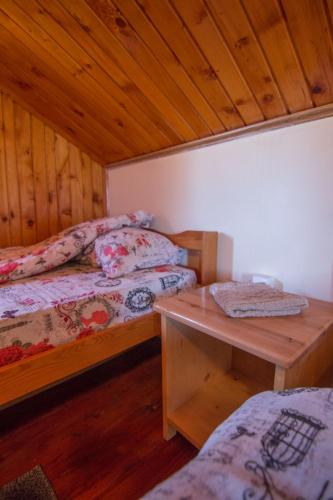a bedroom with two beds and a wooden ceiling at Planinska kuća Petrović in Zaovine