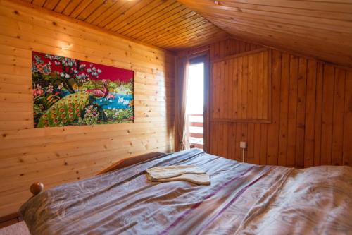 a bedroom with a bed with a painting on the wall at Planinska kuća Petrović in Zaovine