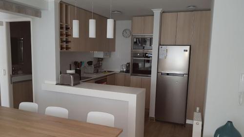 a kitchen with a counter and a refrigerator and cabinets at DEPARTAMENTOS TERMAS DE CHILLAN in Nevados de Chillan