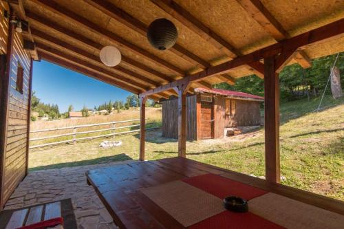 an open porch with a table and a barn at Planinska kuća Petrović in Zaovine