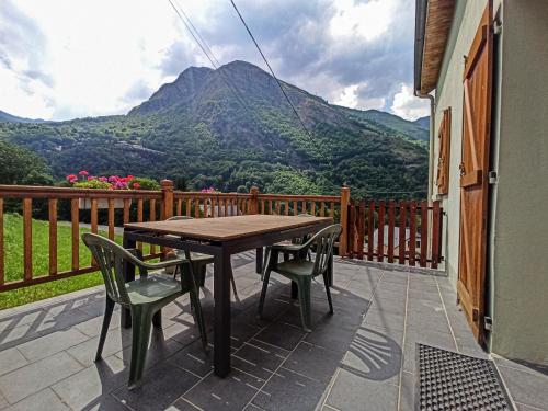 stół i krzesła na balkonie z widokiem na góry w obiekcie Maison de montagne proche Gavarnie 12-14 personnes w mieście Gèdre