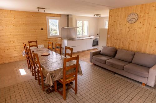 een keuken en eetkamer met een tafel en een bank bij Gite 6 personnes avec terrasse in Gèdre