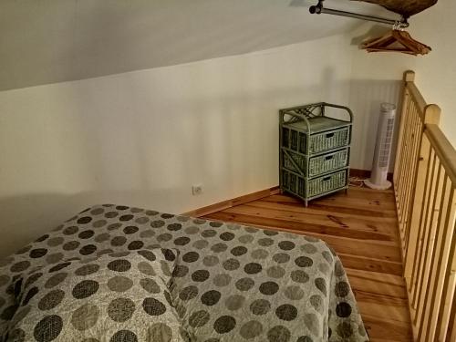 a bedroom with a bed and a dresser on a wooden floor at Les Gîtes sous l' Olivier en Camargue in Vauvert