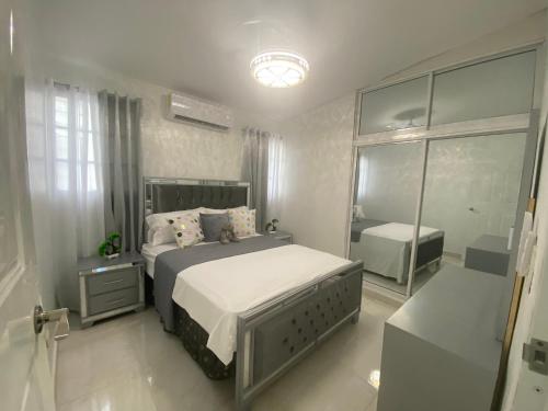 a bedroom with a large bed and a mirror at 7 Santiago Minumental Area Lovely Specially 4 You - Cozy 3 bedrooms WIFI- Caribe tours - Colinas Mall and transportation 24 hours Apartment for 7 peoples in Marilópez