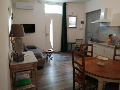a living room with a table and a kitchen at Les Gîtes sous l' Olivier en Camargue in Vauvert