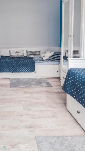 a bedroom with two beds and a wooden floor at Pod Brzozami Apartamenty 5 Mórz in Ustronie Morskie