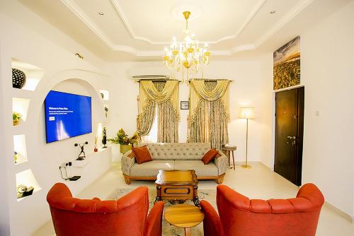 a living room with a couch and two chairs at Kiki's Home and Apartments in Magboro-Akeran
